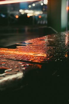 Raindrops on reflective surface with vibrant city lights in Moscow at night, creating a moody urban atmosphere.