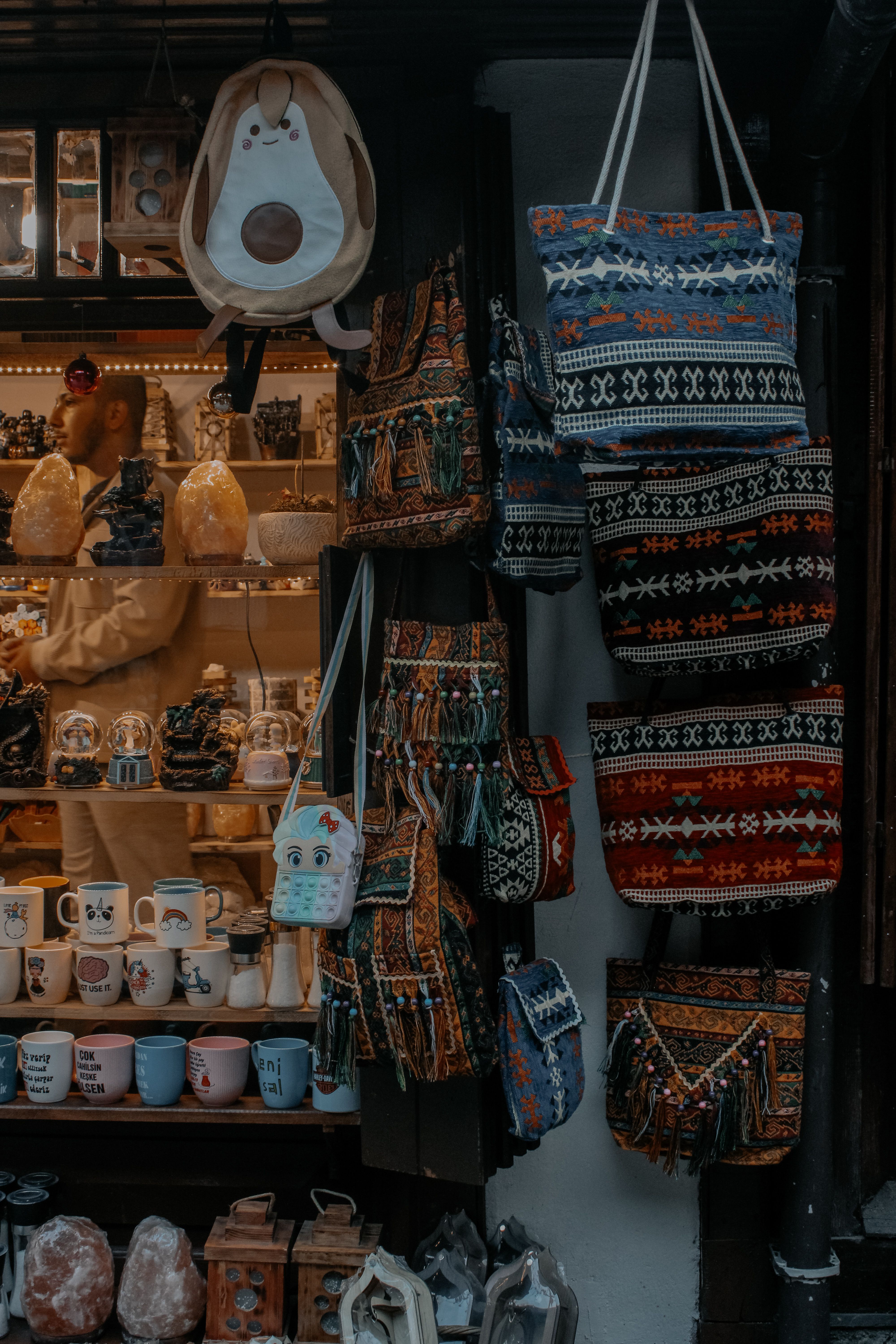 Vibrant woven bags and mugs on display in an artisan market store.