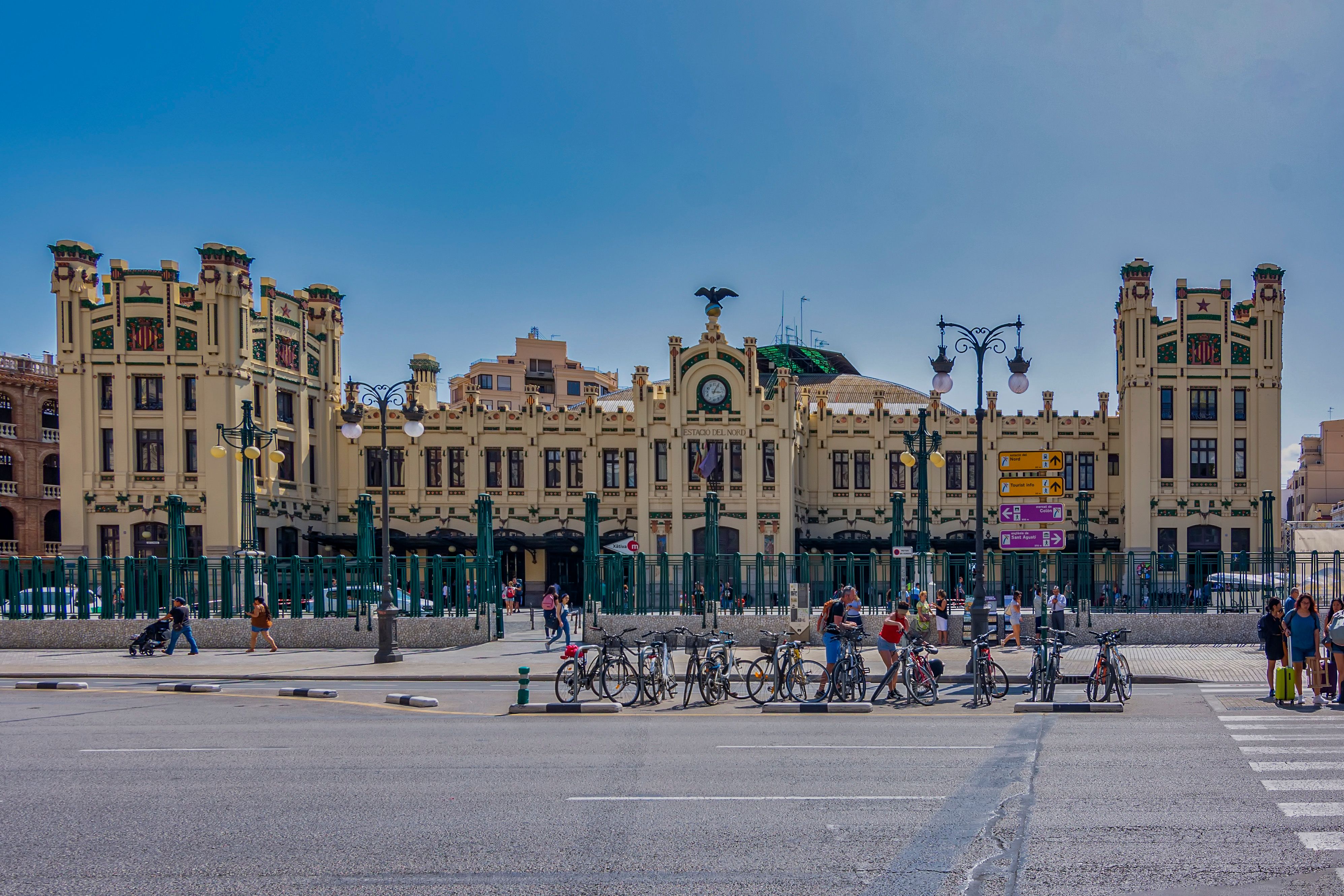 View of Valencia's North Station with people and bicycles on a sunny day. - Valencia
