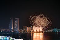 河边的城市天际线被令人惊叹的烟花表演照亮，映照在水面上