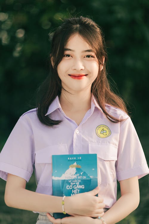 A young woman in a school uniform holding a book