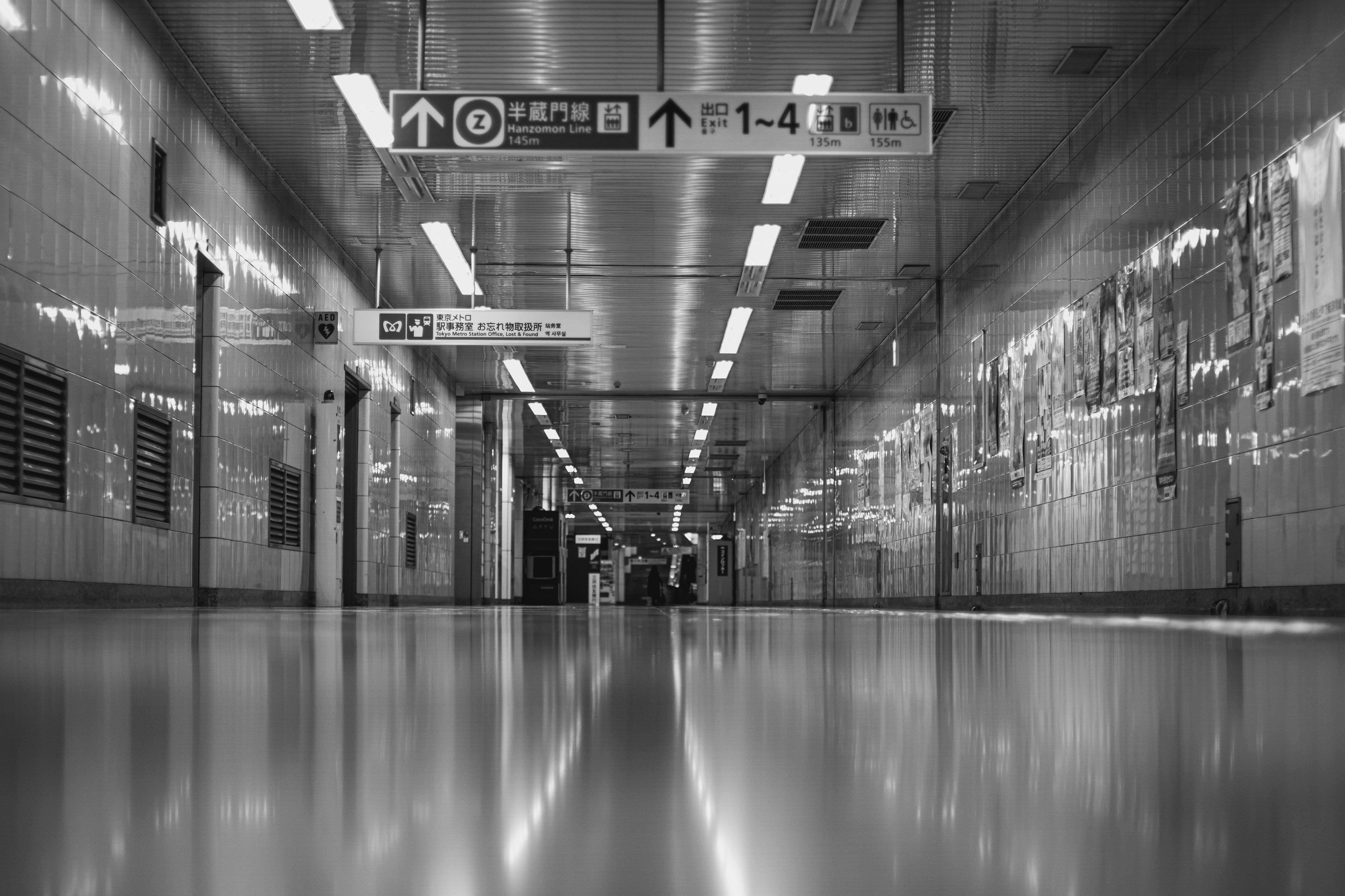 Long underground transfer corridor between subway lines with directional signs