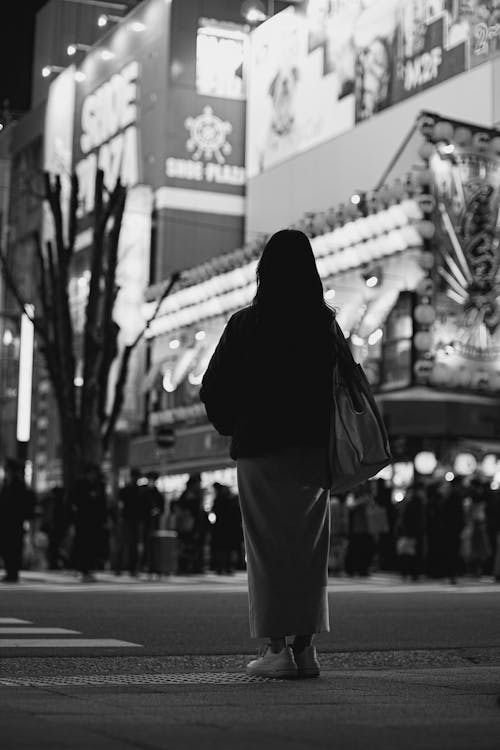 Free A woman is standing in front of a city street Stock Photo