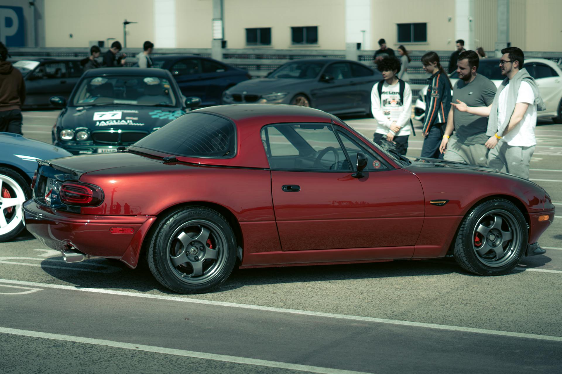 Group of Men Standing by Red Mazda MX-5