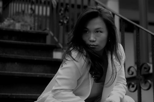 Free A woman sitting on the steps with her hands on her knees Stock Photo