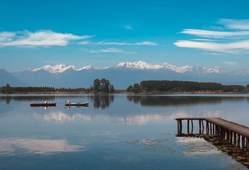 ağaçlar, dağlar, deniz aracı içeren Ücretsiz stok fotoğraf