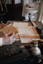 Man Hands Holding Vintage Newspaper over Papers on Table