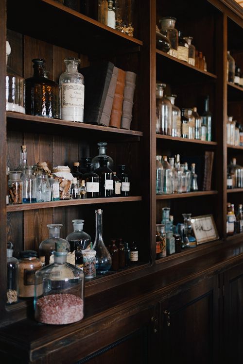 Free A vintage wooden shelf filled with various glass bottles and flasks in a classic apothecary setting. Stock Photo