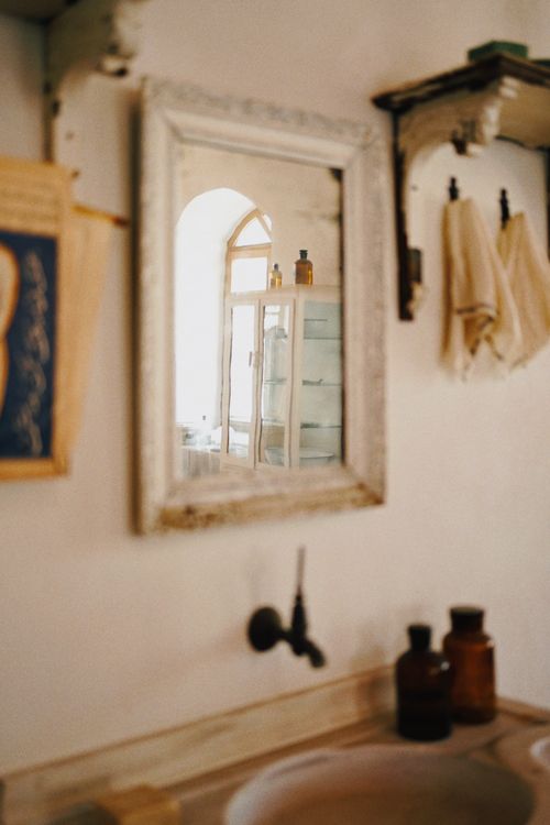 Free A rustic bathroom scene with a vintage mirror reflecting classic decor. Stock Photo