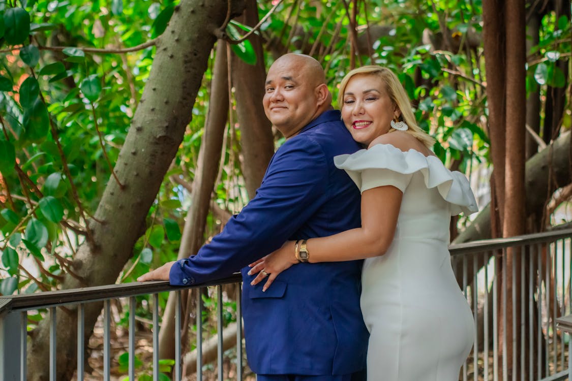 A couple posing for a photo in front of trees