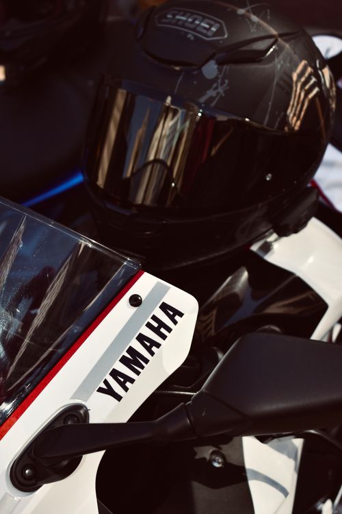 Free Detailed shot of a Yamaha motorcycle with a matching helmet, ideal for motorsport themes. Stock Photo