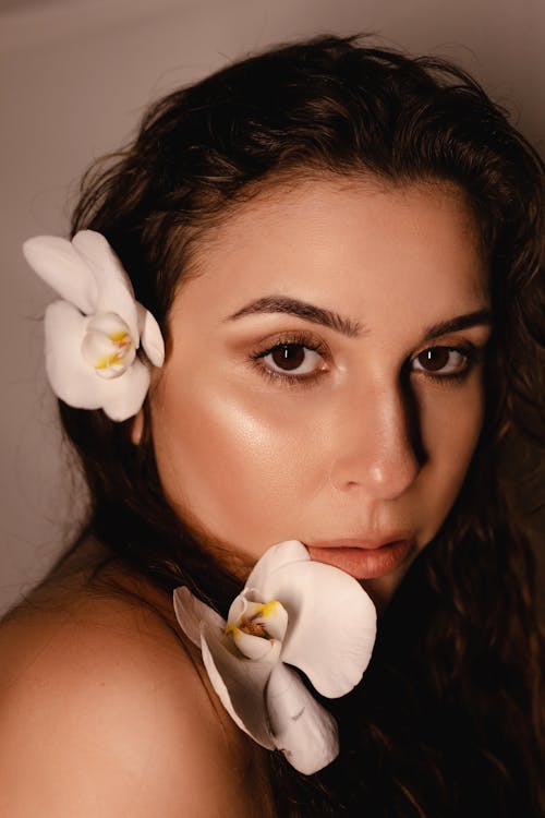 A woman with flowers in her hair posing for a photo