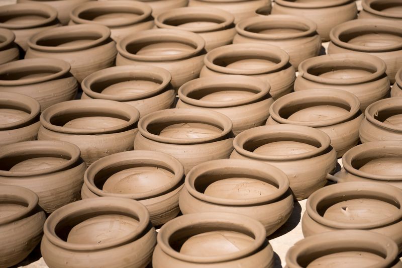 Hands shaping clay on a potter's wheel