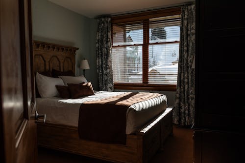 Free A bedroom with a large bed and windows Stock Photo