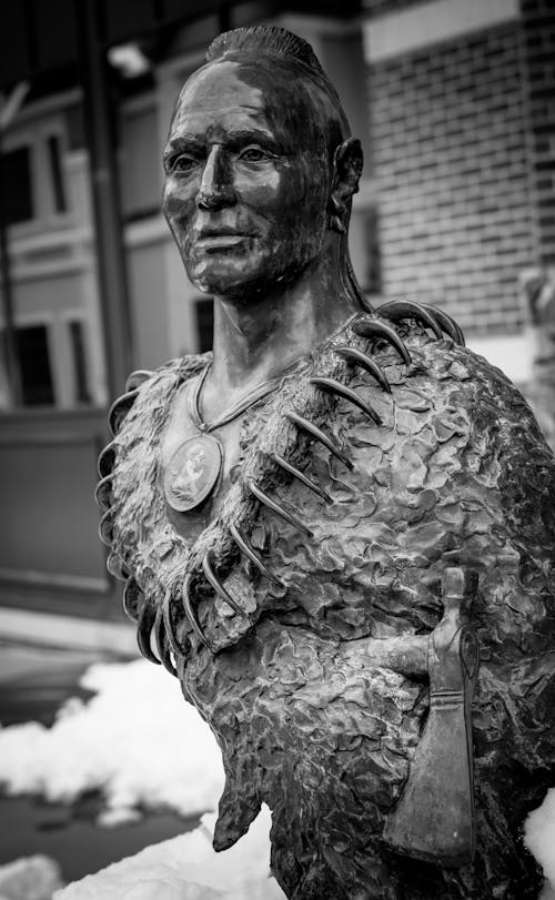 A black and white photo of a statue of a native american