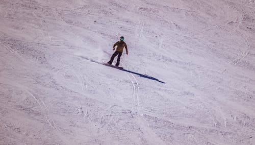 A person riding a snowboard down a snowy slope