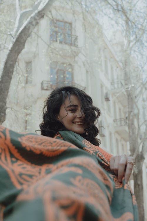 Free A woman is holding a green and orange scarf Stock Photo