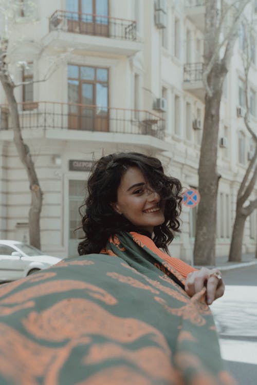 Free A woman holding an orange and green scarf Stock Photo