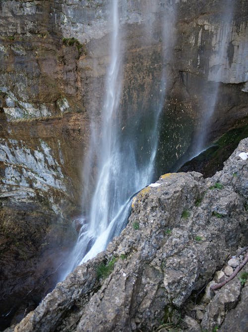 A waterfall is seen from above on a cliff