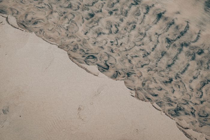 Tide washing over flat sand. Photo by Matias Mango on Pexels