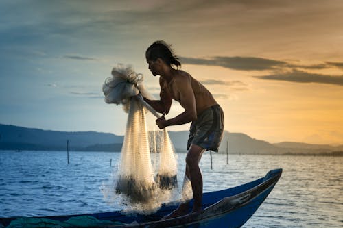 Man Casting White Net At Sea