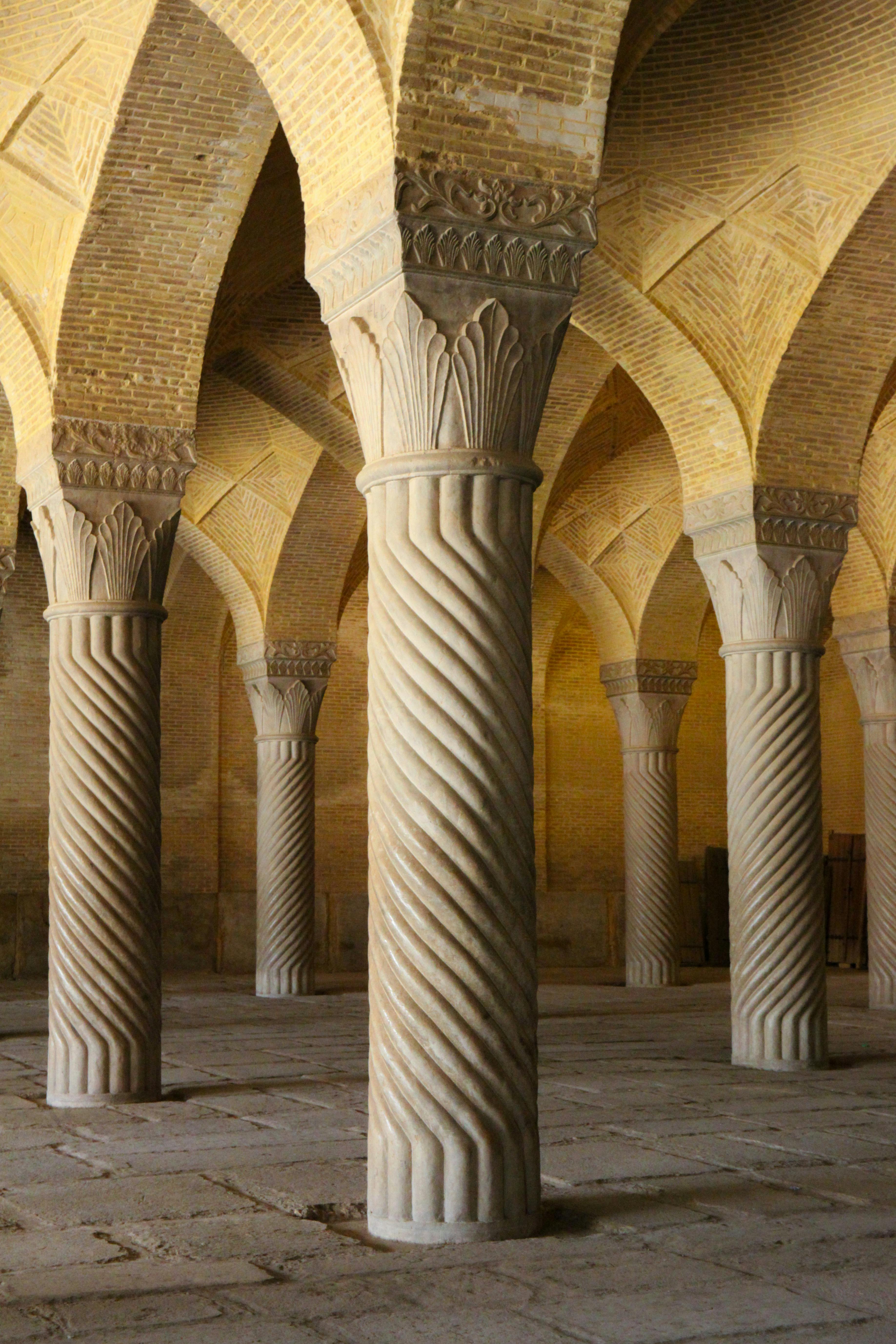 Intricate spiral columns inside Vakil Mosque, a prominent Islamic landmark in Shiraz, Iran.