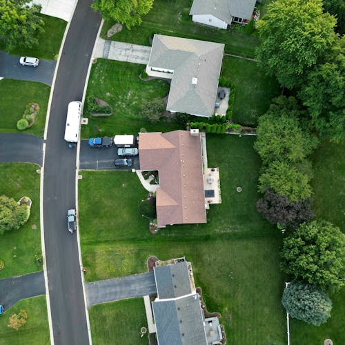 Aerial view of a suburban neighborhood with a driveway and a house