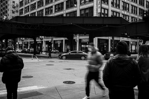 Free Black and white photo capturing people on a bustling Chicago street with iconic architecture. Stock Photo