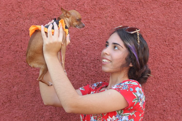 Smiling Brunette Woman Holding Puppy Dog