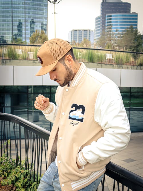 A man wearing a baseball jacket and hat