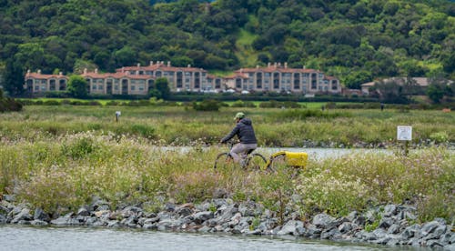 A man on a bike rides by a river