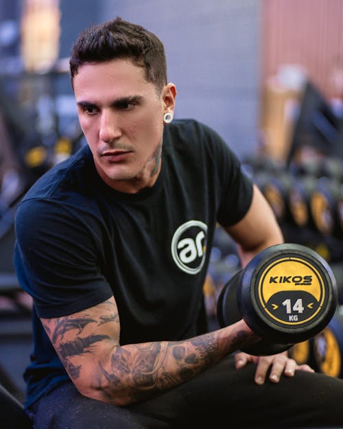 A man with tattoos holding a dumbbell