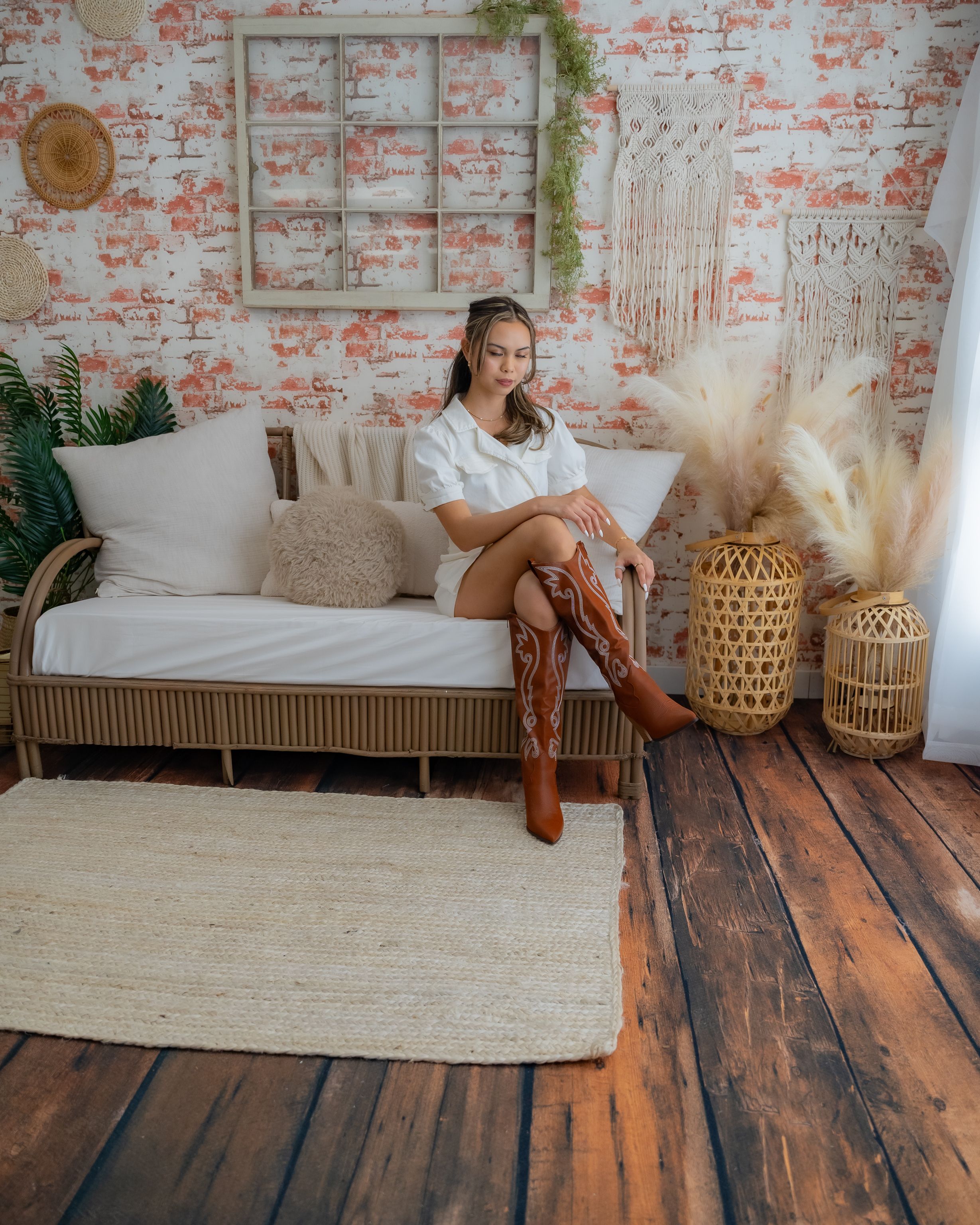 Model in White Mini Dress and Brown Cowboy Boots Sitting on the Sofa  Free  Stock Photo