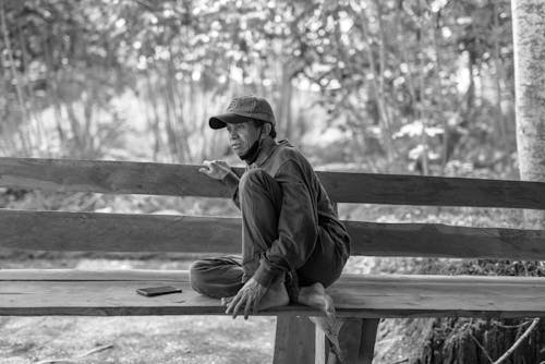 Free A man sitting on a bench in the woods Stock Photo