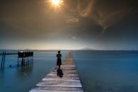 阳光普照的木板路上，一个人影走在宁静的海洋边