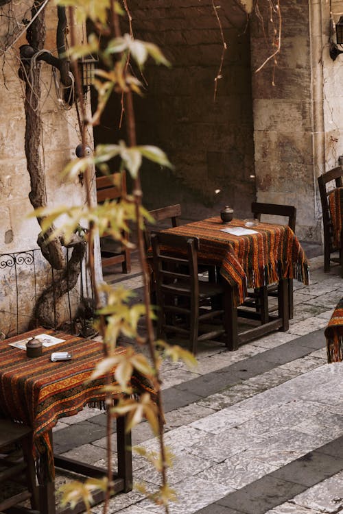 A restaurant with tables and chairs in the middle of a courtyard