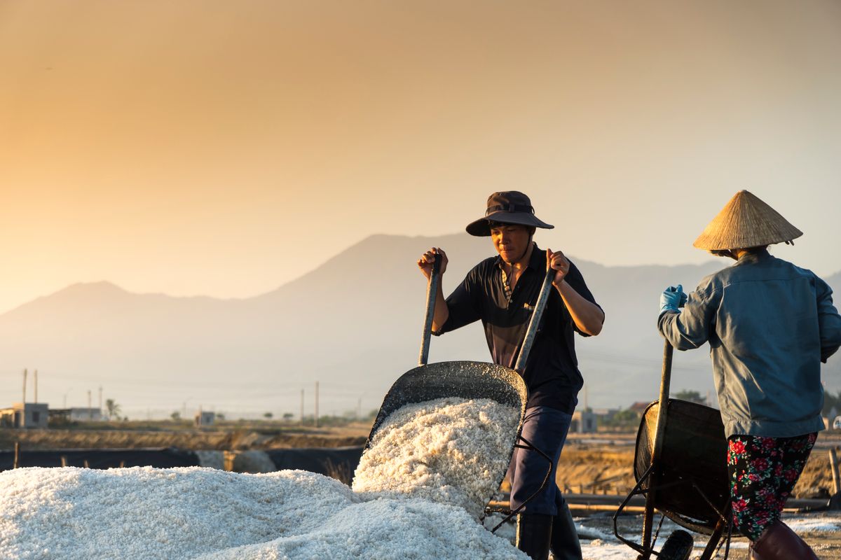 Two workers resting with their barrows as the sun drops