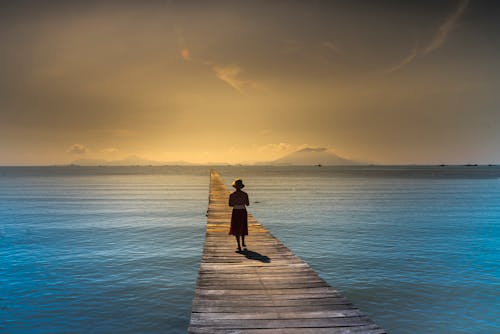 Frau, Die Eimer Hut Trägt, Der Auf Brauner Hölzerner Promenade Geht