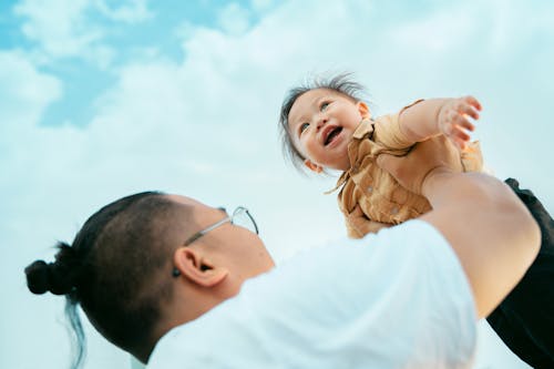 Father Holding Son in Raised Arms