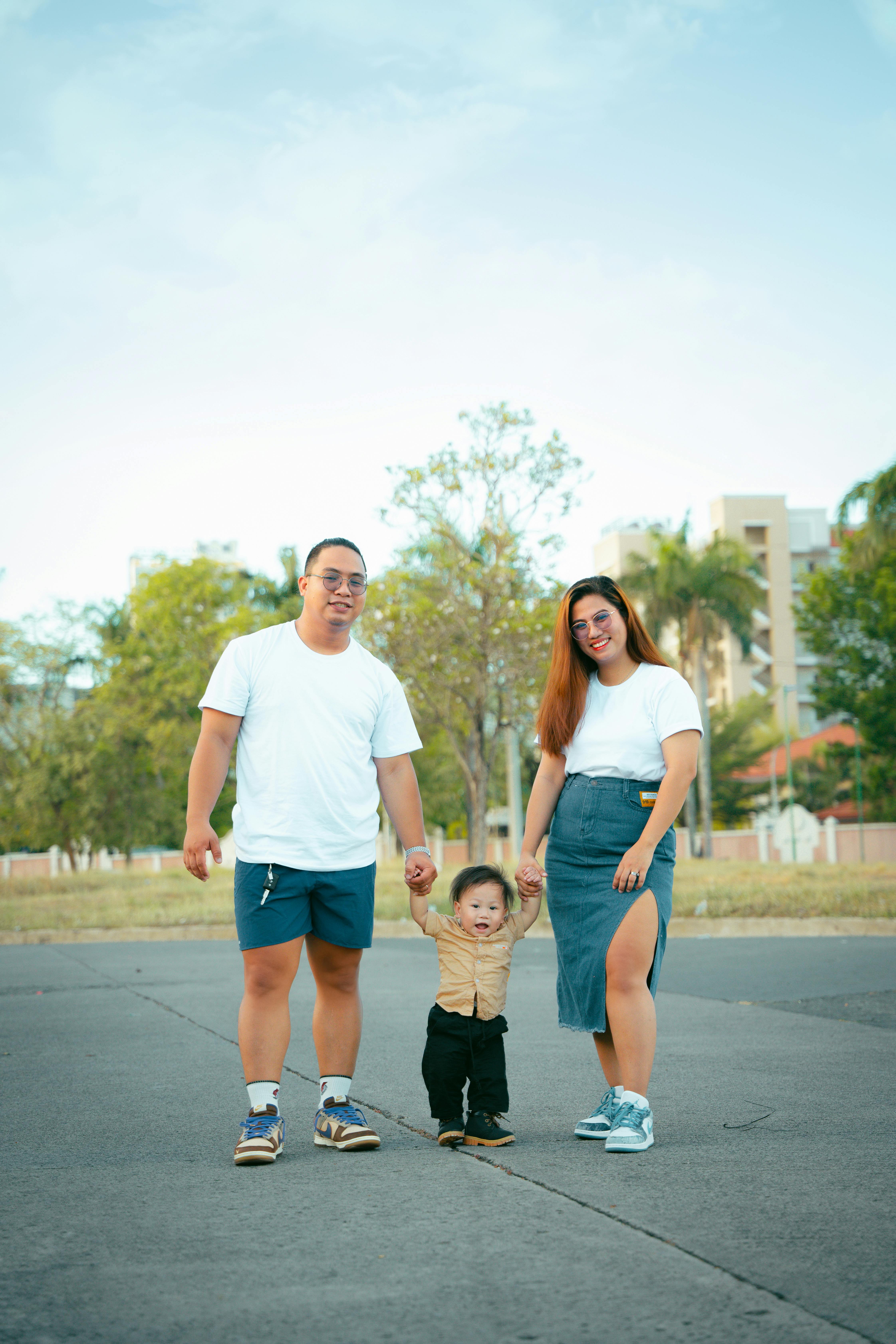 A cheerful family enjoying a daytime walk in an urban park setting.