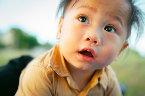 Free Portrait of a curious young child with a surprised expression outdoors on a sunny day. Stock Photo