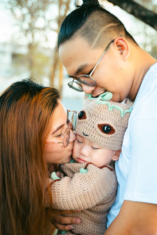 Free A man and woman holding a baby and a man wearing glasses Stock Photo