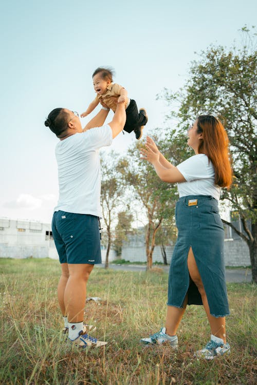 Free A man and woman holding a baby in the air Stock Photo