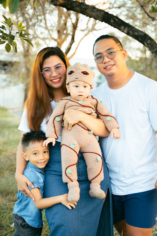 Free A family poses for a photo in front of a tree Stock Photo