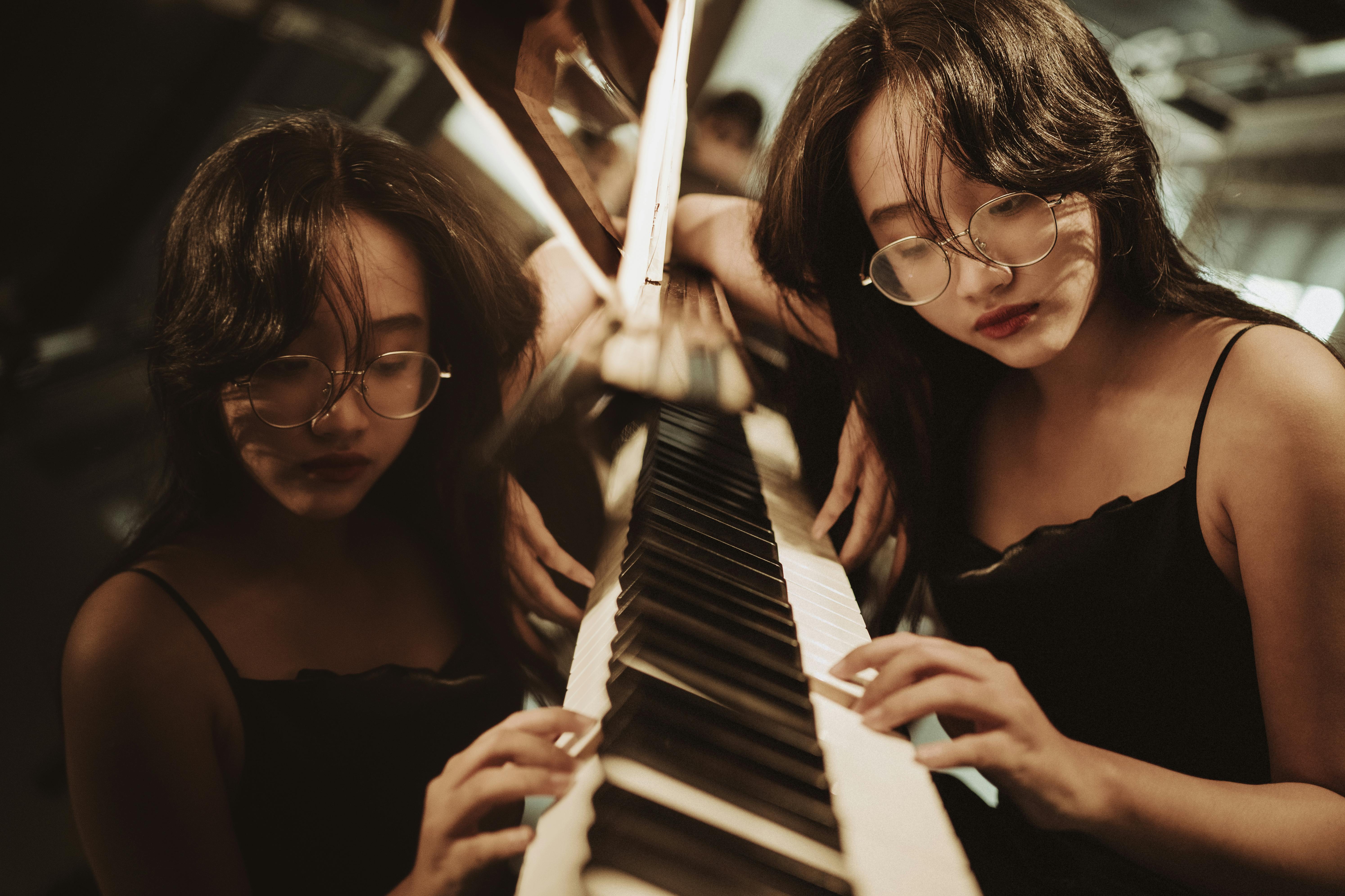 A stylish young woman playing piano, captured with a vintage feel indoors. Artistic and moody setting.