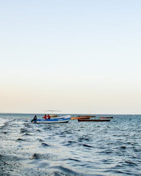 日落时分，肯尼亚马林迪宁静的水域上，渔船捕捉到沿海的宁静氛围