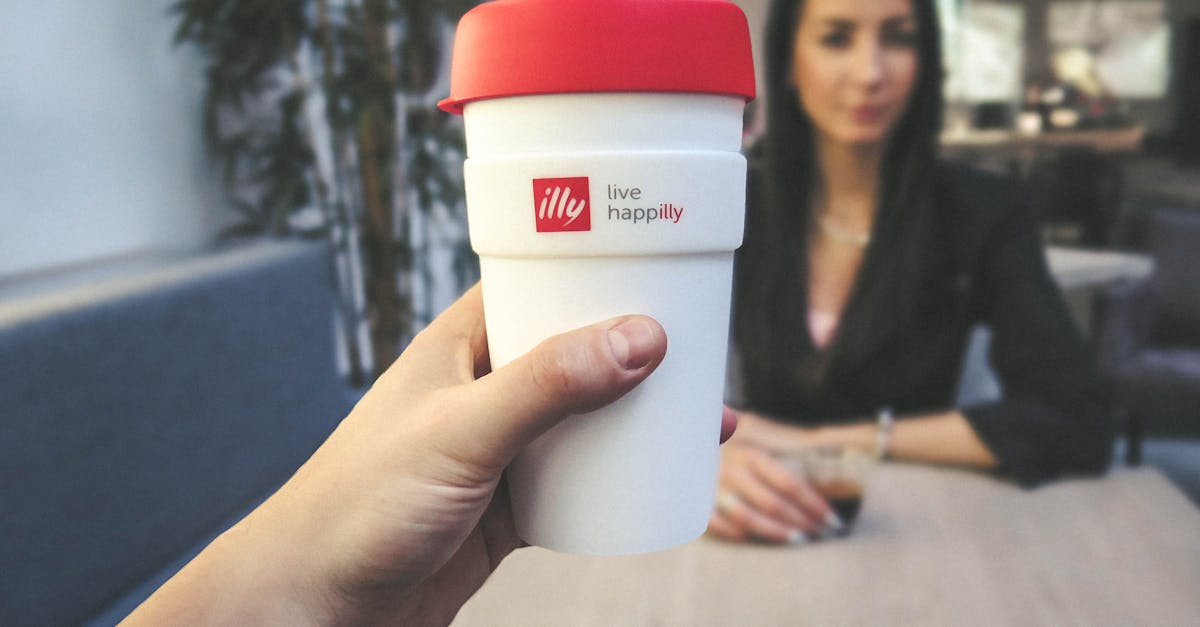 Person Holding White and Red Live Happilly Cup