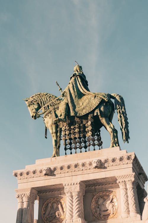 A statue of a man on a horse in front of a blue sky