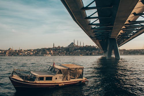 Free View of a Boat on the Bosphorus Strait under the Golden Horn Bridge Stock Photo