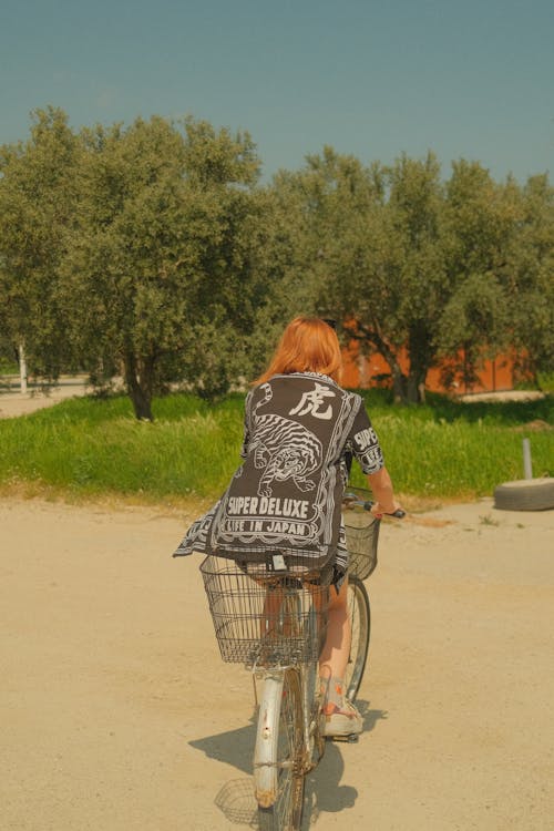 A woman riding a bike with a bag on it